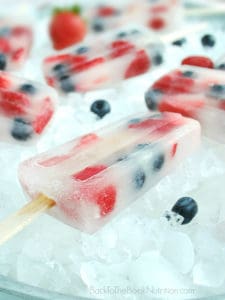 Healthy and refreshing red, white, and blue popsicles made from just coconut water and fresh berries - perfect for the 4th of July! | Back To The Book Nutrition