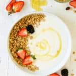 Homemade yogurt in a white bowl topped with granola and berries