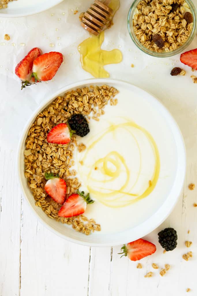 Homemade yogurt in a white bowl topped with granola and berries