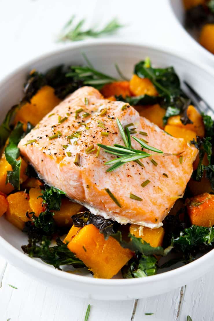 A close up of easy salmon and roasted butternut squash and kale in a white bowl