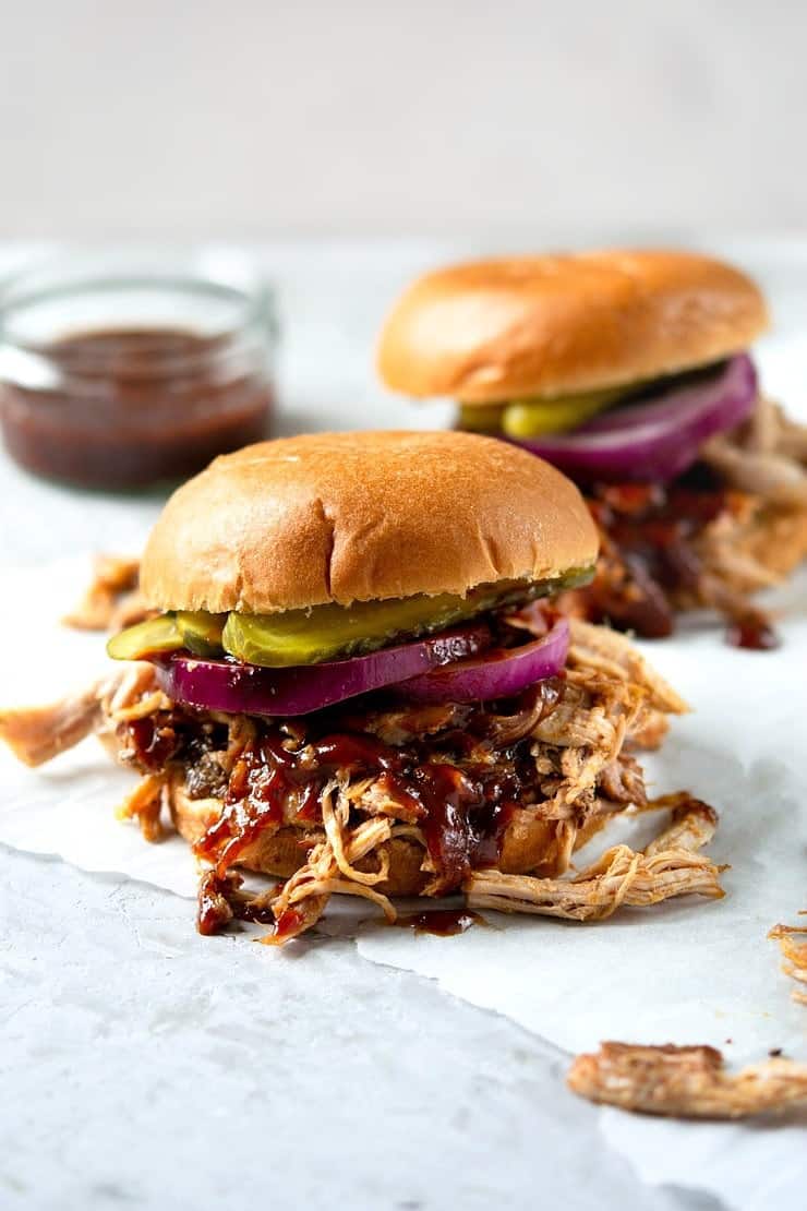 A close up of a pulled pork sandwich with bbq sauce