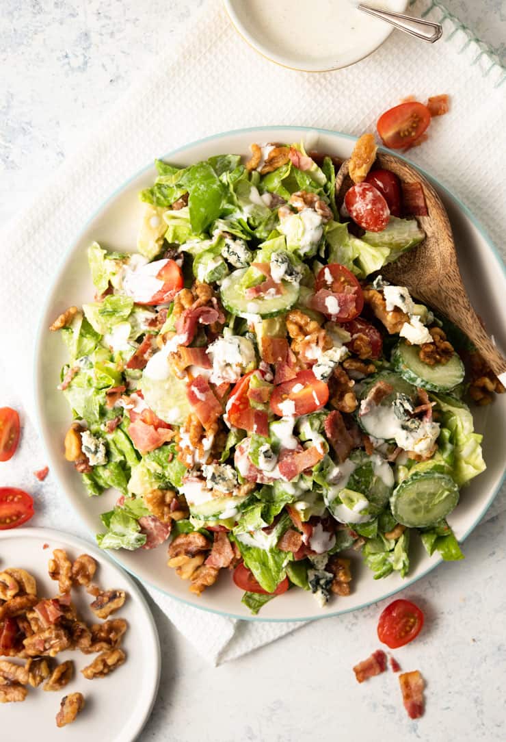 Overhead shot of a blue cheese salad with bacon, avocado and walnuts