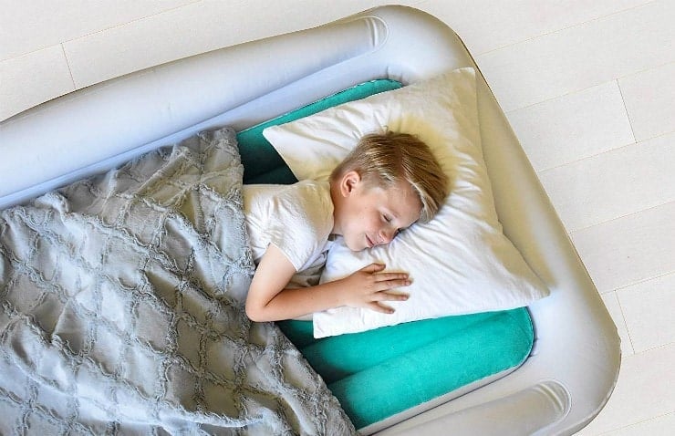 young boy sleeping on inflatable mattress