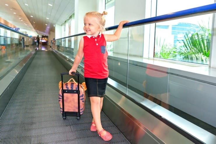 Girl pulling roller backpack carry on through airport