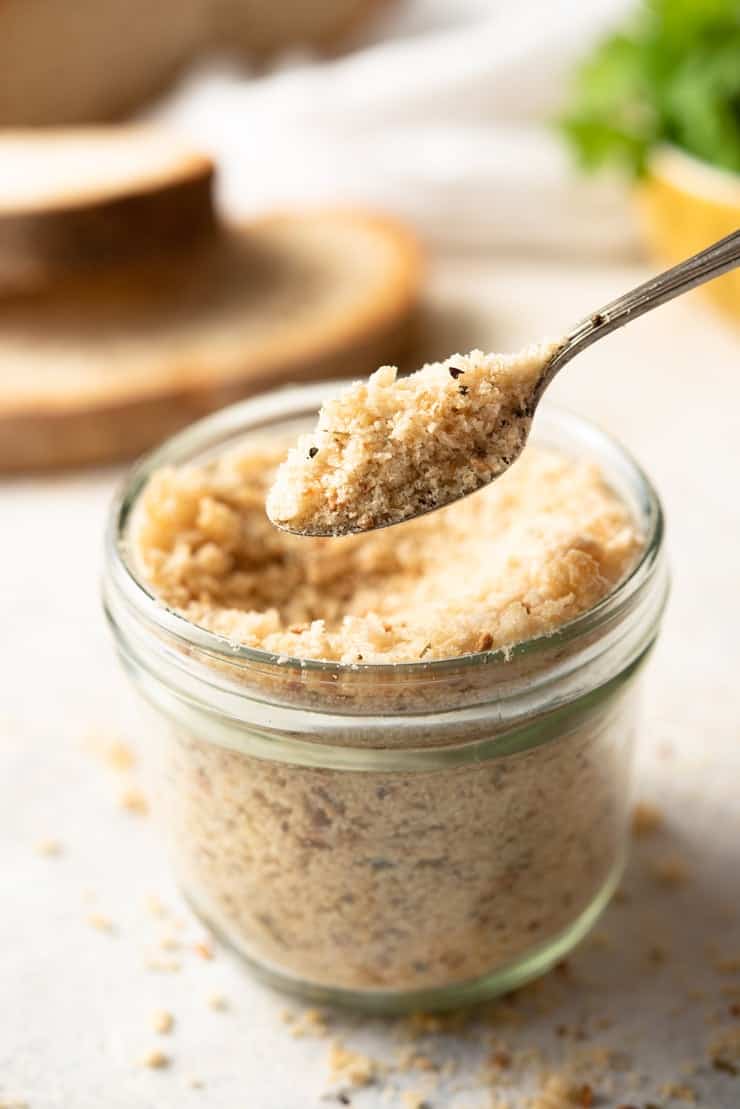 A close up of a spoonful of homemade panko crumbs in a glass jar 