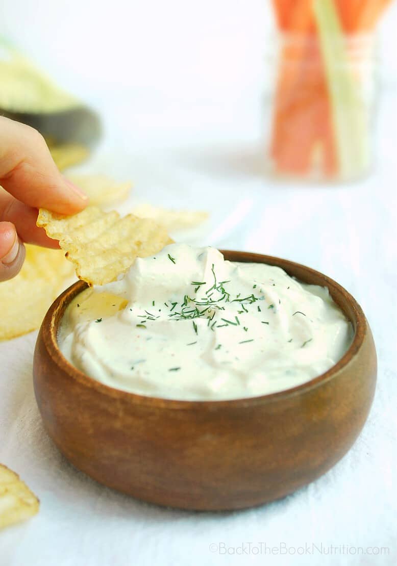 close up image of dipping potato chip into bowl of 5 minute ranch dip