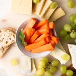 An overhead shot of fermented carrots on a cheeseboard