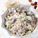 Rotisserie chicken salad in a white dish with grapes and crackers