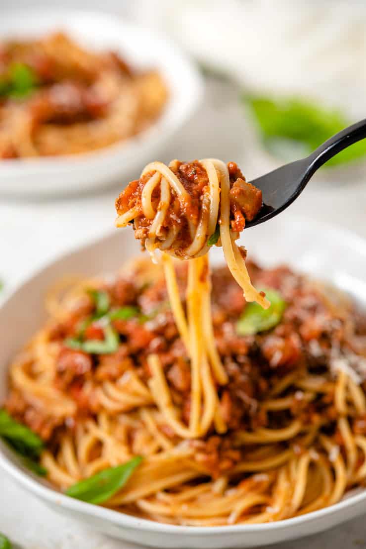 A close up of spaghetti with meat sauce on a fork