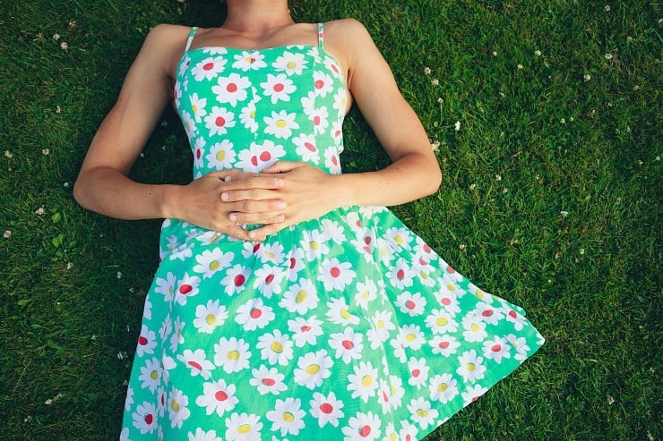 woman in flowered dress lying on grass