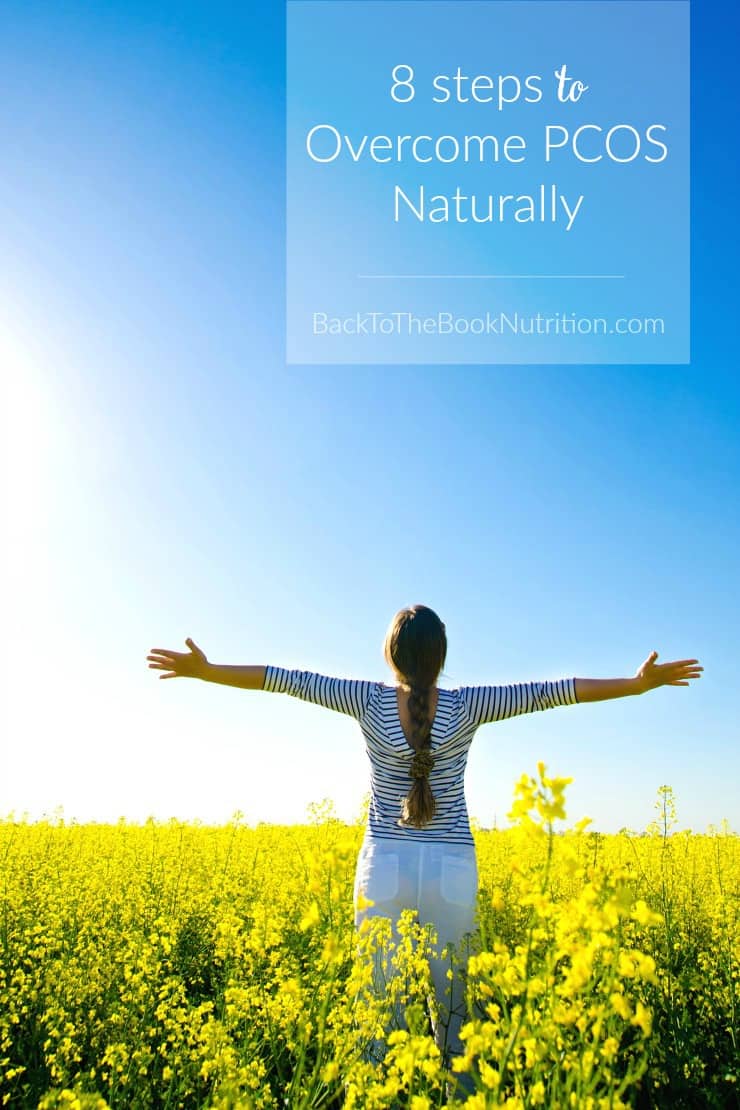 woman standing in field with arms outstretched 