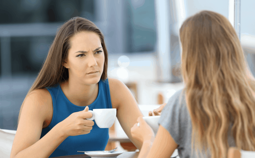 two young woman in serious conversation at coffee shop