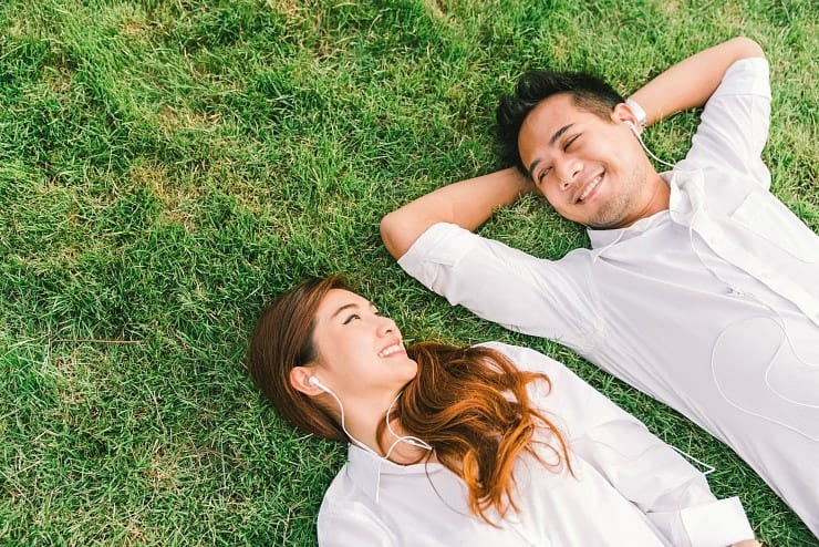 young couple lying in grass together