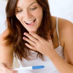 woman excited about positive pregnancy test