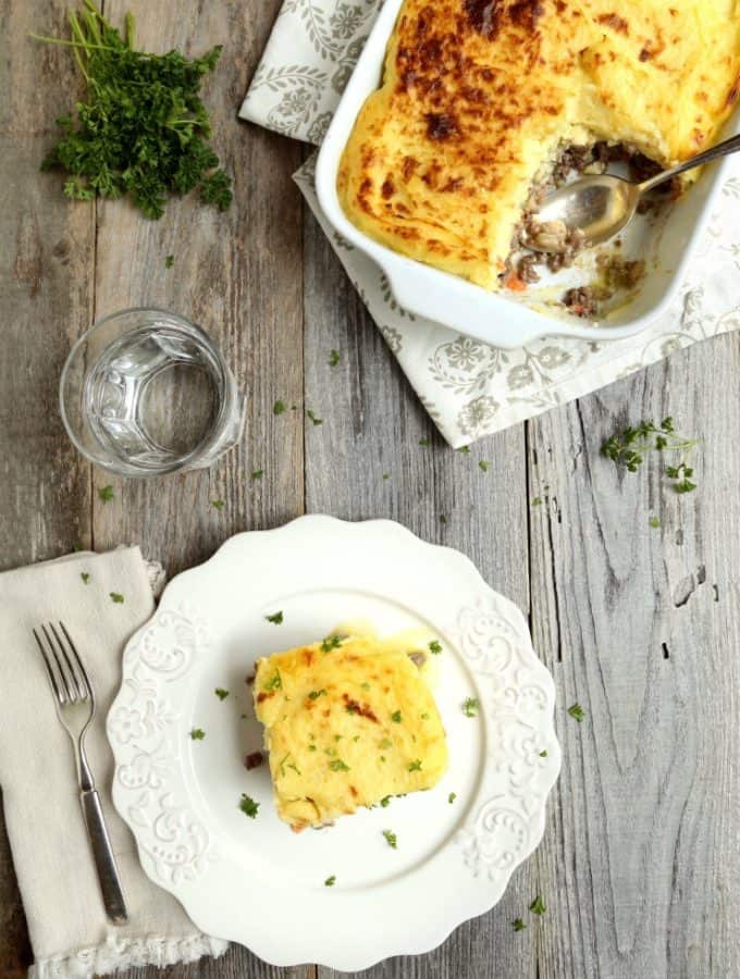 overhead view of cottage pie in pan and one serving on plate