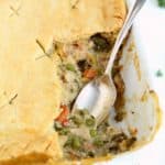 close up of turkey pot pie in pan with 1 serving removed