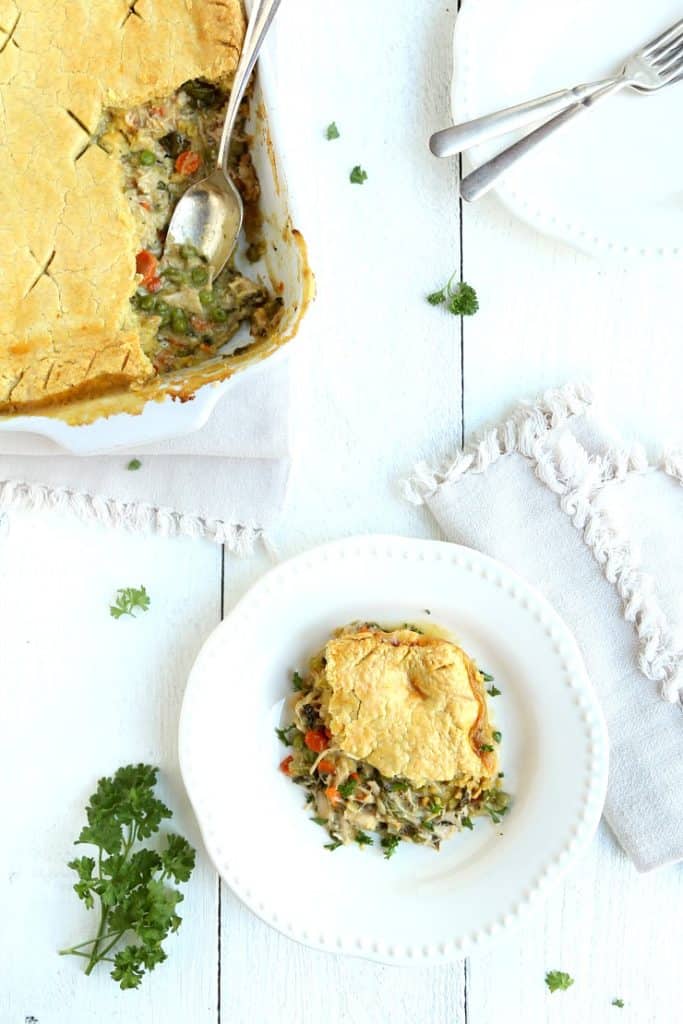 overhead shot of turkey pot pie in pan with 1 serving on plate