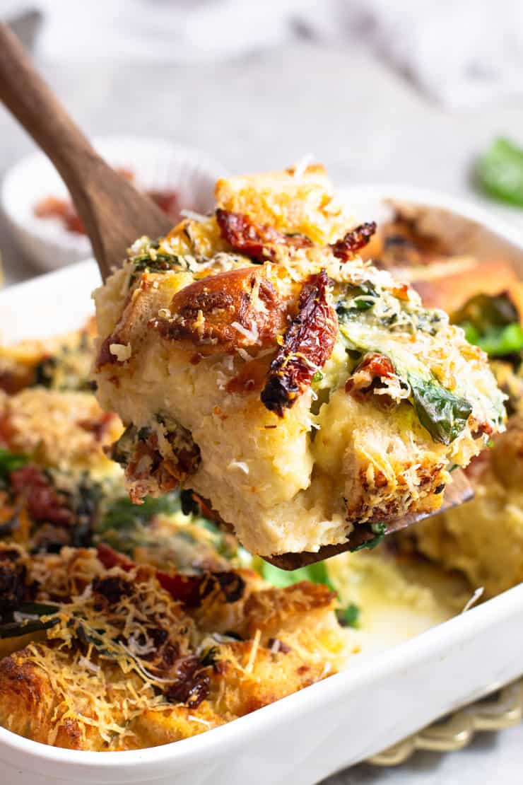 A close up of a slice of breakfast strata with spinach 