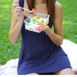 image of woman eating salad on picnic blanket overlayed with article title: 6 signs your diet is really disordered eating