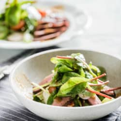 front image of two bowls of salad with sliced beef