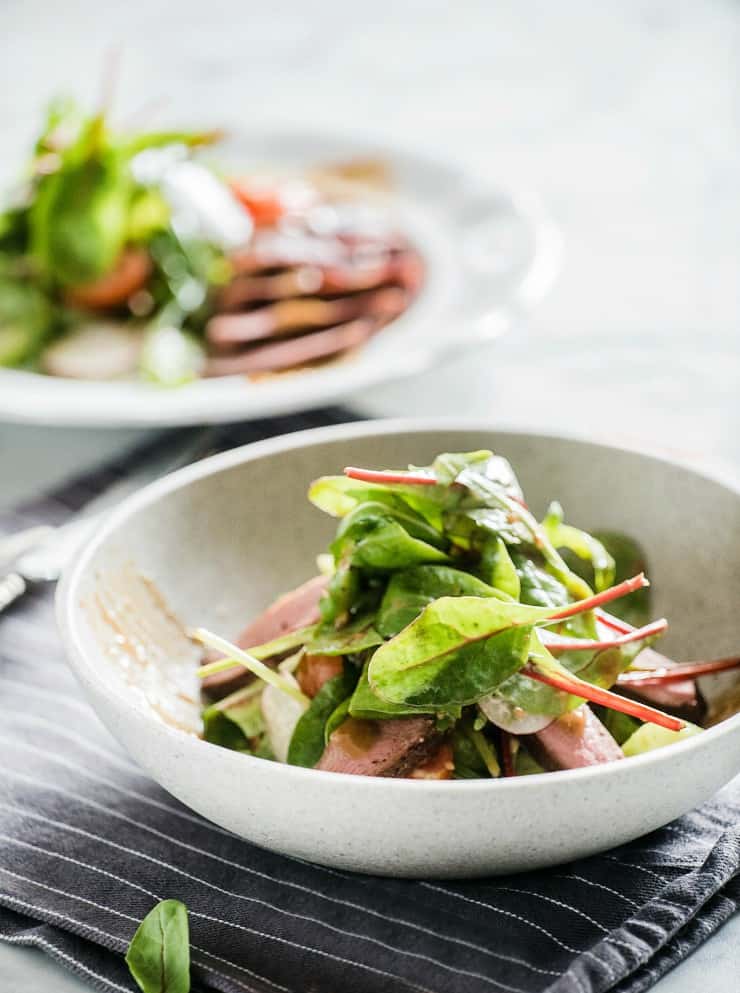 front image of two bowls of salad with sliced beef