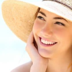 happy young woman on beach with sun hat