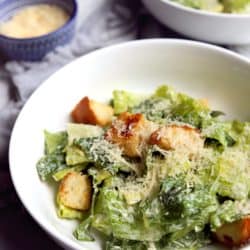 close up view of Caesar salad in bowl on marble background