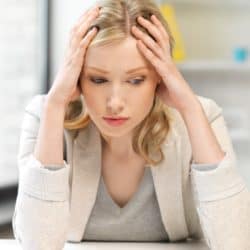 blonde woman feeling stressed at her work desk