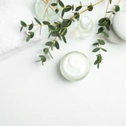 overhead image of natural face cream and white towel on white background