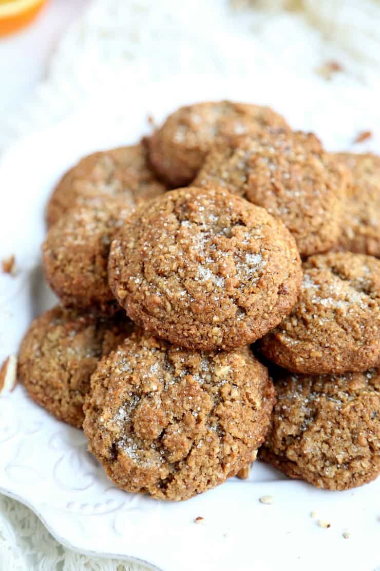 Close up view of pile of pecan flour spice cookies on white plate