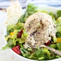 Close up image of Magic Everything Tuna Salad on a bed of greens with a bite on a fork.