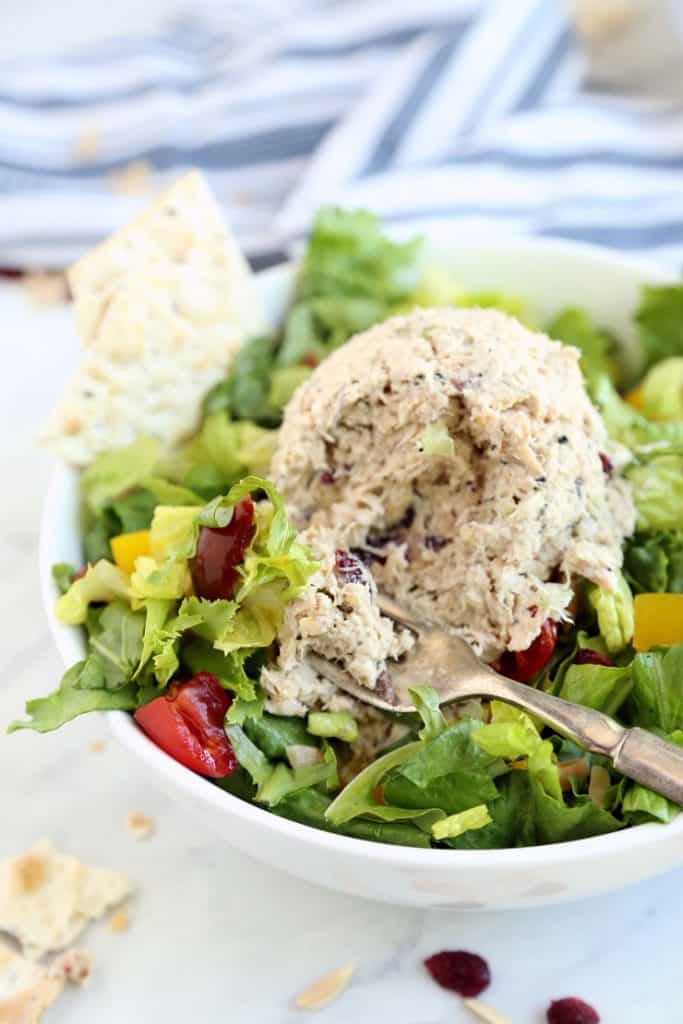 Close up image of Magic Everything Tuna Salad on a bed of greens with a bite on a fork.