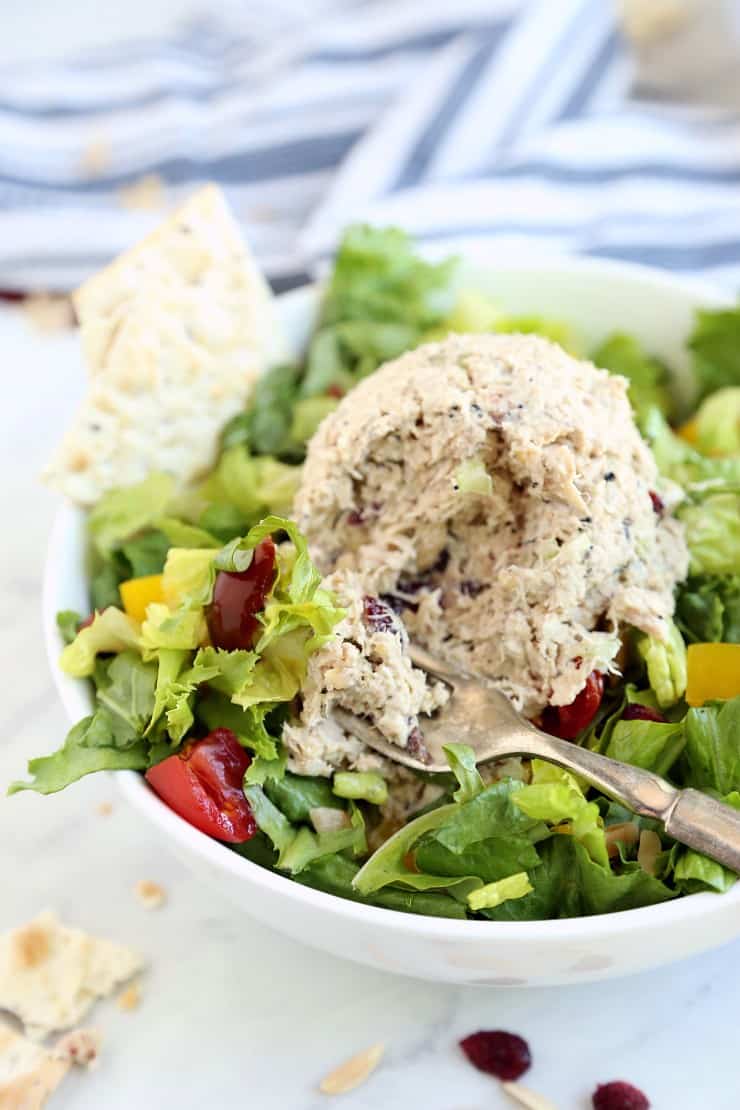 Close up image of Magic Everything Tuna Salad on a bed of greens with a bite on a fork.