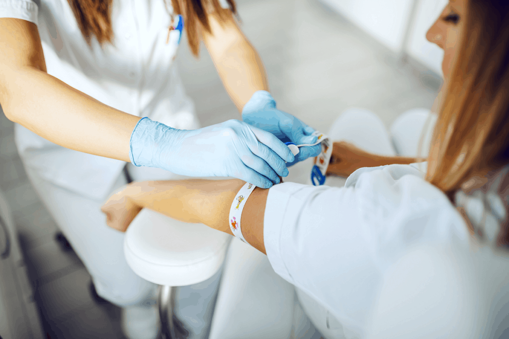 Phlebotomist preparing to draw blood from woman's arm