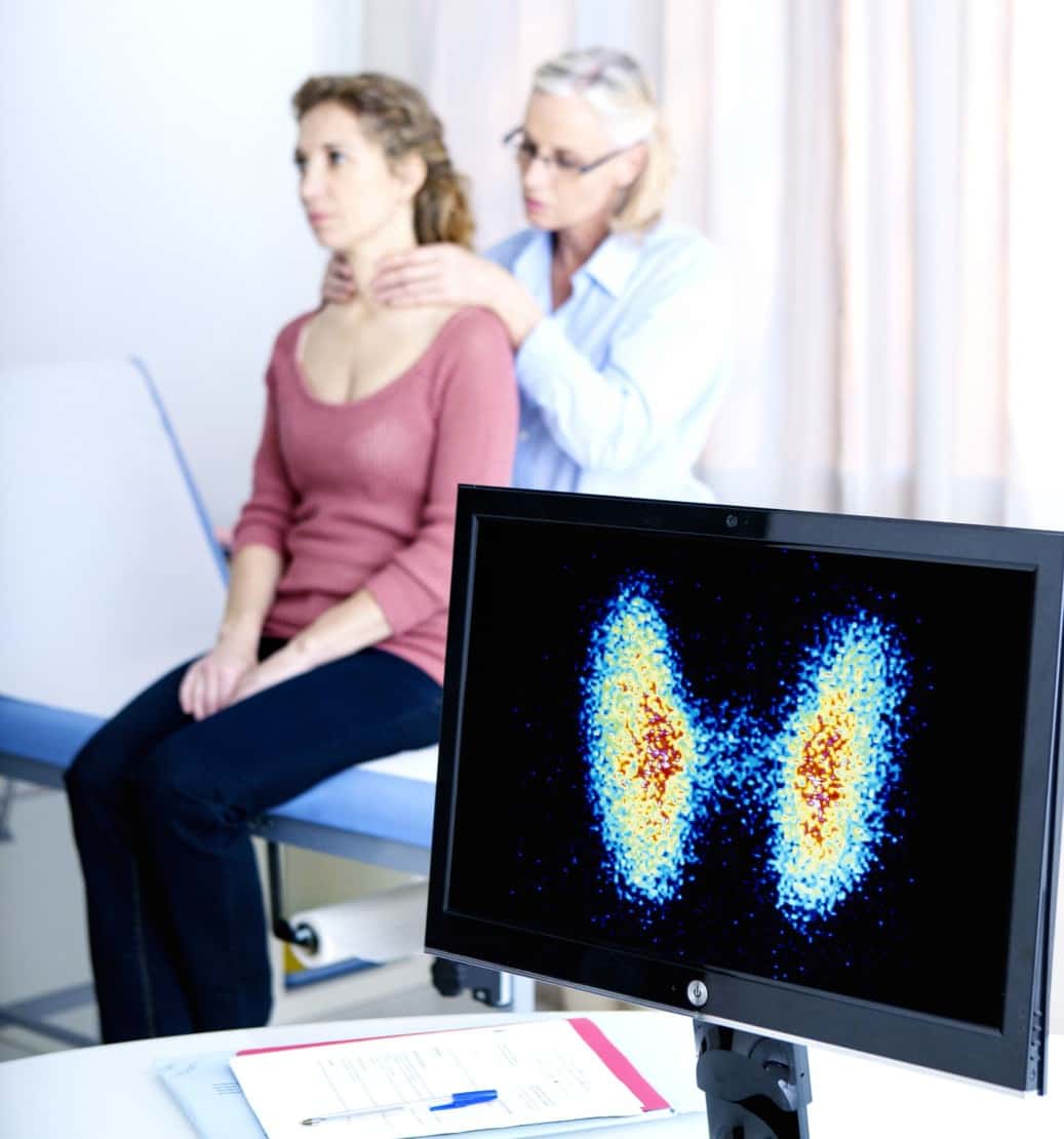 woman getting thyroid exam by doctor