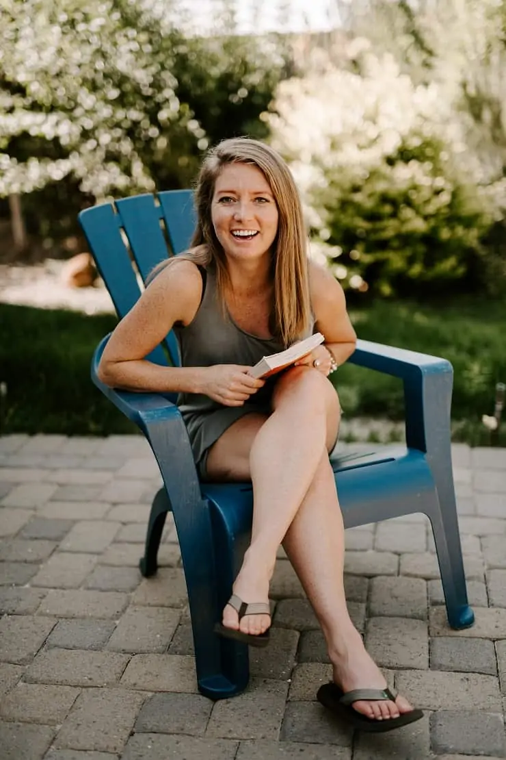 Julia laughing sitting outdoors in an adirondack chair