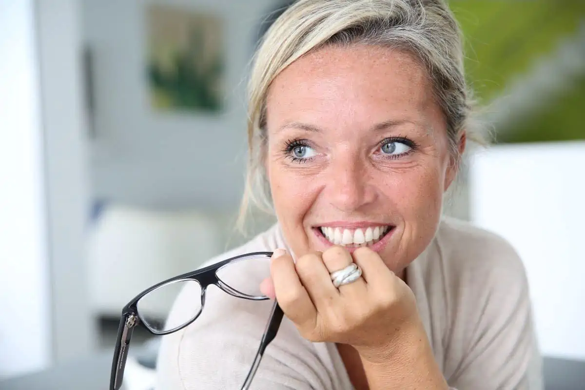 40 something blonde woman smiling at desk 